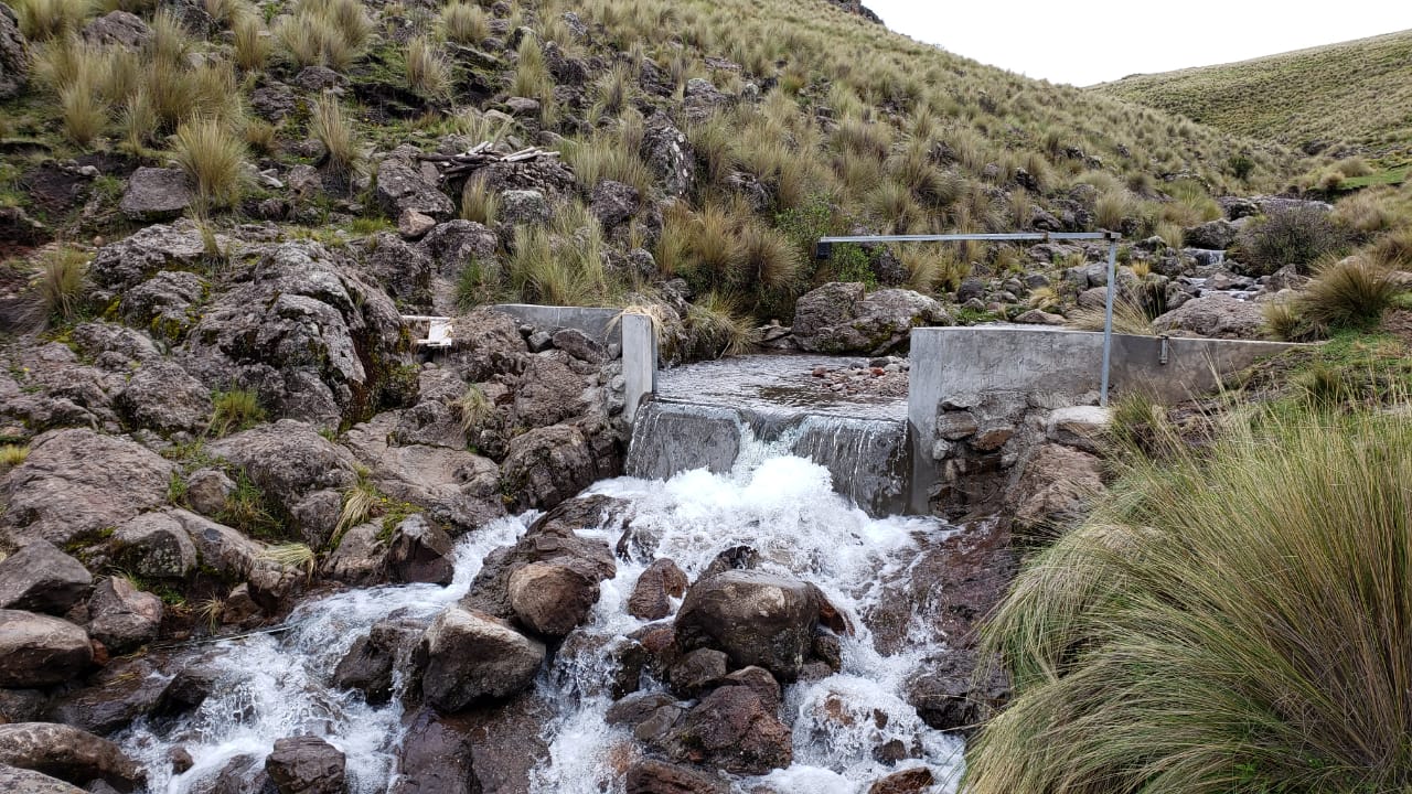 Un técnico instalando un sensor en un paisaje peruano.